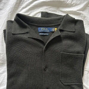 Mörkgrå merinoullsskjorta Polo Ralph Lauren - Säljer en väldigt fin Ralph Lauren-overshirt. Den har inte varit i min ägo alls länge, men känner att den inte är ”jag” riktigt. Materialet är 100% tvättbar merinoull, vilket gör den extra exklusiv. Med anledning av materialet har tröjan inte fått hänga i garderoben, utan legat vikt i en låda. Det är alltså ett oerhört skönt, lyxigt och trevligt plagg - perfekt inför hösten. Pris kan diskuteras. 