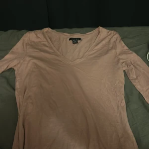 Beige långärmad v-ringad tröja Amisu XS - Långärmad tröja från Amisu i en snygg beige nyans. Modellen har v-ringning och är tillverkad i en mjuk blandning av bomull och modal, vilket gör den superbekväm. Perfekt för dig som gillar en enkel och stilren look.