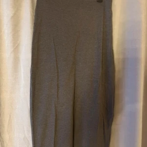 Grå långkjol från Even&Odd - Enkel och stilren grå långkjol från Even&Odd. Kjolen har rak passform och är tillverkad i mjukt stretchigt material som känns bekvämt mot huden. Perfekt att matcha med en crop top eller stickad tröja för en chill look.