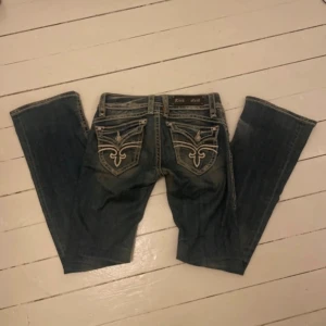 Rock Revival blå bootcut jeans - Vintage low rise bootcut jeans från Rock Revival. Tidigare mina favorit jeans men inte använts på ett tag. Midjemått är cirka 37 cm tvärsöver och innerbenslängden är ca 84cm. Grenmåttet är 18! Jeansen stretchar även lite