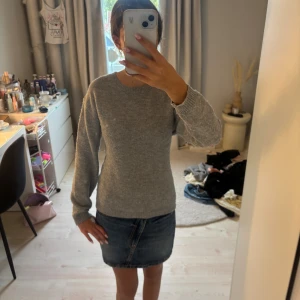 Grå stickad tröja med rund hals - En enkel och stilren grå stickad tröja med rund halsringning och långa ärmar. Perfekt för lager-på-lager och funkar till både jeans och kjol. Mjuk och skön känsla, passar dig som gillar en klassisk look.