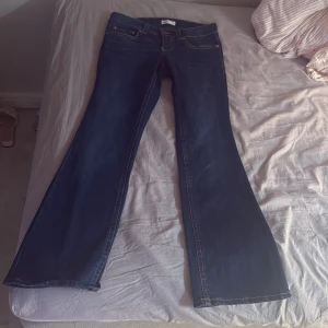 Bootcut jeans från Perfect Jeans - Mörkblå bootcut jeans från Perfect Jeans med snygga kontrastsömmar och klassiska fem fickor. Baktill finns två fickor med lock och knappdetalj. Jeansen har låg midja och är tillverkade i ett stretchigt denimtyg för skön passform. Helt ny skick , oanvänd , skriv om du vill ha frågor 💕