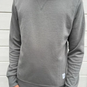 Mörkgrå sweatshirt från  XS - Säljer en stilren mörkgrå sweatshirt från Jack & Jones Essentials i storlek XS. Tröjan har rund halsringning, ribbade muddar och en klassisk passform. Perfekt för dig som gillar enkla och snygga basplagg. Materialet är mjukt och skönt bomullstyg.