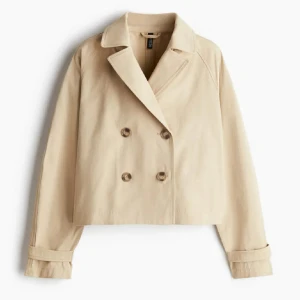 Beige kort trenchcoat från H&M - Säljer min trenchcoat från hm då den inte kommer till användning längre💕sparsamt använd💕kan gå ner i pris vid snabb affär! Stilren och kort trenchcoat i beige från H&M med dubbelknäppning framtill och klassisk krage. Jackan har långa ärmar med dekorativa band vid ärmsluten och en rak, boxig passform. 