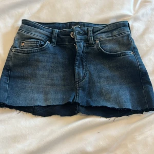 Mörkblå jeanskjol från ONLY XS - Snygg mörkblå jeanskjol från ONLY i klassisk femficksmodell. Kjolen har rå kant nertill för en cool, avslappnad vibe och en liten nitar-detalj på myntfickan. Perfekt för dig som gillar denim och vill ha en kort kjol med edge. Skriv för frågor eller om ni är intresserade ❤️