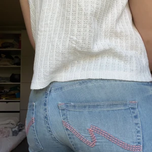 Ljusblå bootcut Nelly jeans - Ljusblå Nelly jeans med två knappar och har rosa detaljer på bakfickorna. De har en liten fläck på baksidan men de syns inte mycket alls! Byxorna har inte används mycket. Kom gärna med prisförslag🩷