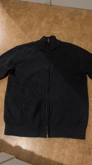 Stickat hel zip - Säljer en stickad helzip-tröja i mjukt och behagligt material. Tröjan har dragkedja hela vägen fram, ribbade muddar och en klassisk passform som funkar till både vardag och skola. Den är varm, bekväm och i fint skick utan noppor eller skador. Perfekt som lager på lager eller som lätt jacka.