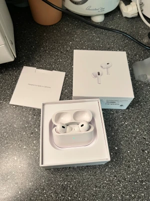 AirPods Pro 2 - Apple AirPods 2 Pro i mycket fint skick, komplett med originalförpackning och tillbehör. Trådlösa hörlurar med aktiv brusreducering och laddningsetui. Inga repor eller skador, ser oanvända ut. Perfekt för musik, samtal och träning. Finns även kvitto vid intresse.