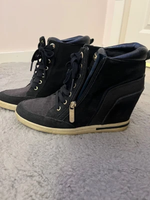 Tommy Hilfiger Wedge Skor - Mörk blåa Tommy Hilfiger wedge sneakers med guld detaljer i storlek 38. Köpt från second hand och använt en gång. 