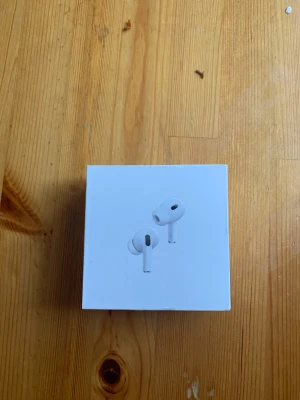 AirPods Pro - Säljer ett par Apple AirPods Pro 2 med originalförpackning. Laddningsetuiet har synligt slitage och smuts, men fungerar som det ska. Perfekt för dig som vill ha trådlösa hörlurar med aktiv brusreducering och hög ljudkvalitet. Säljer endast laddningsetuit 