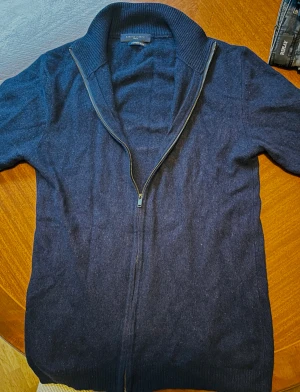 Mörkblå fullzip från Daniele Fiesoli - Snygg mörkblå fullzip från Daniele Fiesoli med hel dragkedja och ribbad krage. Tillverkad i en mjuk cashmere blend som känns lyxig och skön mot huden. Perfekt för dig som gillar stilrena och klassiska plagg med en modern touch. Nypris: 2000kr