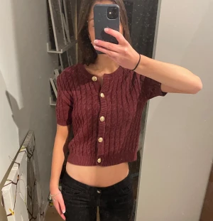 Vinröd stickad topp med guldiga knappar - Jättesnygg och julig/höstig stickad topp från H&M. Jag är 172cm, för referens. Endast använt några gånger.