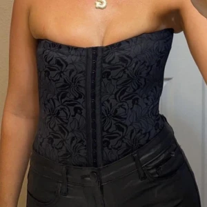 Svart korsett  - Snygg svart korsett från maidenform. Storlek M men skulle säga att den passar S-M