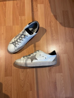 Golden Goose Superstars  - Säljer ett par riktigt Sköna Golden Goose Superstars i storlek 42. Skorna är både extremt snygga men även väldigt bekväma att ha på sig, perfekt för en stilren men bekväm look! Skorna är i fint skick. Orginalpris: ca 4000kr/ Mitt pris: 1599kr. Pris går att diskuteras! Skriv vid minsta fundering!💯