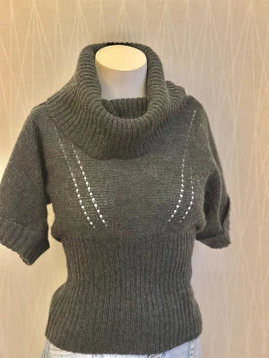 kortärmad polotröja - Grå, kortärmad polotröja med ribbad nederkant och muddar samt dekorativa håldetaljer Det står XS men kan också passa S och M.