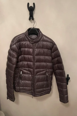Grå Moncler Acorus  - Moncler acorus dunjacka Köpt förra året. Dragkedjan funkar som vanligt men det man drar i har lossnat, har kvar delarna för att laga den. Har ej kvittot men ”prislapp”. Billigt pris pga dragkedjan samt små hål vid armarna. Kemtvättad. Ända andledningen för att jag säljer är för att den är för kort annars hade jag haft kvar den. Självklart är den äkta 