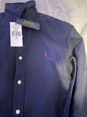 Mörkblå skjorta Polo Ralph Lauren - Köptes för 1499kr Mörkblå långärmad skjorta från Polo Ralph Lauren i slim fit-modell. 