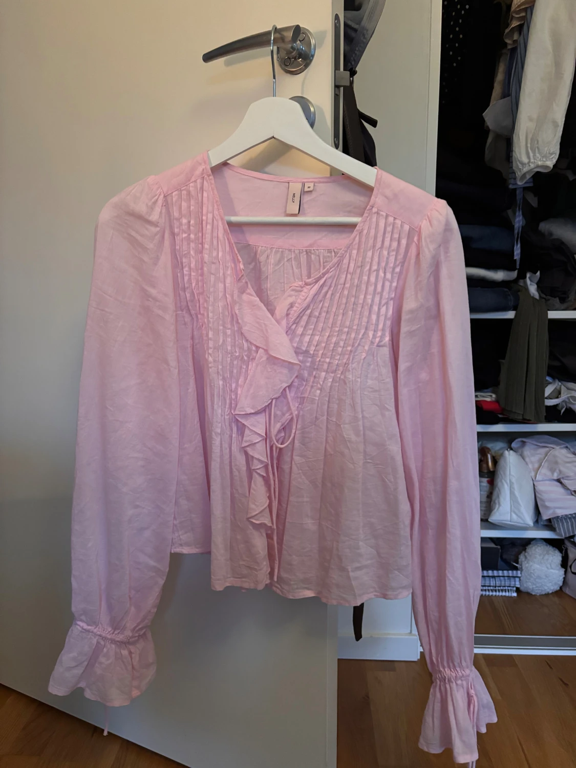 Ljusrosa blus med volanger från Nelly