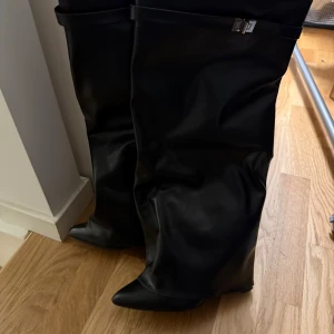 Svarta boots - Säljer ett par höga svarta boots i storlek 39 från pretty little things. Skorna har en fold-over design och når upp till knäna. Använd en gång.