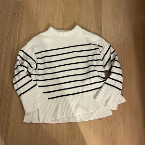 Vit och svart randig stickad tröja 157 - Vit stickad tröja från 157 i storlek XS med svarta horisontella ränder. Tröjan har breda ribbade muddar vid ärmslut och nederkant samt en rund halsringning, skriv om du har några funderingar💕