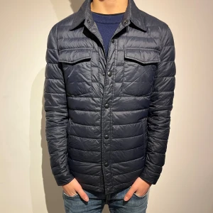 Massimo Dutti jacka - Snygg mörkblå quiltad jacka från Massimo Dutti med klassisk krage och tryckknappar framtill. Jackan har två bröstfickor med lock och två sidofickor. Perfekt för dig som gillar stilren och modern look.