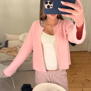 Rosa kofta från Neo Noir - Superfin ljusrosa kofta från Neo Noir i mjuk, ribbstickad kvalitet. Koftan har rund hals, knappar framtill och långa armar. Kontakta för fler frågor 💘