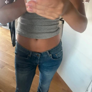 Blå lågmidjade bootcut jeans - Snygga blå jeans med låg midja och bootcut passform. Jeansen har klassisk femficksdesign, lätt slitna detaljer och är tillverkade i ett mjukt denimtyg. Perfekta för dig som gillar en avslappnad och trendig look.