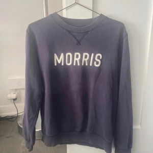 Mörkblå sweatshirt från Morris Co - Snygg mörkblå sweatshirt från Morris Co i storlek small. Tröjan har klassisk rund hals, ribbade muddar och vit broderad MORRIS-text på bröstet. Perfekt för chill dagar och enkel att matcha med jeans eller joggers.
