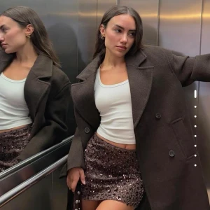 Bershla Brun kappa  - Säljer en brun, lång och oversized kappa med breda slag och dubbelknäppning framtill. Jackan har en stilren look med två sidofickor och är helfärgad utan mönster. Materialet är ullblandning som ger en mjuk och varm känsla. Den kostar nästan 900 på bershkas hemsida säljer för 650 för att bli av med snabbt. Den är använd under oktober månad bara. Såå varm och passar till vintermånaderna Storlek xs men den är oversize så jag som vanligtvis har S/M i kläder tycker den är väldigt lös i passformen. 