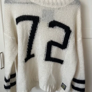 Stickad tröja Superdry storlek L -  stickad tröja från märket Superdry. Tröjan har rund hals och är grovstickad. Oversized passform. Tröjan är vit med svarta detaljer Material: akryl, nylon och mohair. 