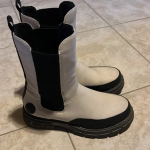 Vita boots med svarta detajer  - Vita boots med svarta detaljer fårn Rieker. 