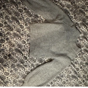 Grå ribbad stickad tröja Gina Tricot - Säljer en grå stickad tröja från Gina Tricot i storlek XS. Tröjan har ett ribbat mönster, rund hals och långa ärmar. Perfekt för dig som gillar enkel och stilren look med lite loose passform. Supermysig att bära under kyliga dagar. Något oversize passform passar därmed även de som bär S.