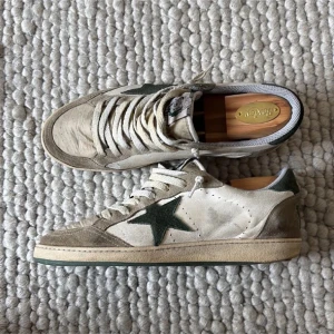 Golden goose  - Golden Goose Ball Star sneakers i beige och grön mocka och skinn, med ikonisk stjärndetalj på sidan och VCE-text på hälen. Klassisk låg modell med snörning och perforerade detaljer. Storlek 44 men passar även 45. Nypris mellan 6000 och 7000 tusen. Ingen låda kommer med. Priset är inte hugget i sten och vid frågor eller funderingar är det bara att skriva🙏❤️ 