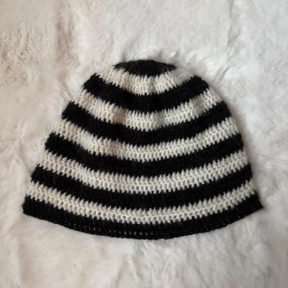 Randig svartvit virkad mössa
