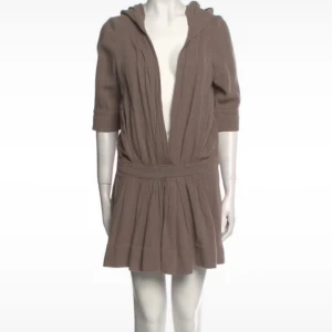 Beige kort klänning Isabel Marant linne - Superfin beige kort klänning från Isabel Marant i 100% linne med djup v-ringning, trekvartsärm och huva. Klänningen har markerad midja och lätt rynkad kjol för en avslappnad men chic look.