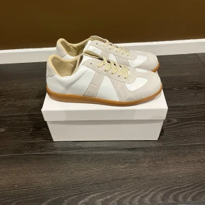 Maison margielas  - Säljer ett par maison margielas Gats, strl 44 vit. Passar med många outfits och är sköna. Skriv vid frågor! Även dustbag och låda medföljer!