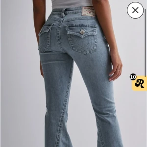 True Religion ljusblå bootcut jeans - Säljer ett par ikoniska blå bootcut jeans från True Religion med snygga detaljerade bakfickor och låg midja. Jeansen är uppsydda 5cm i benen,   professionellt på Johnells och passar mig perfekt i längden som är  166🥰❤️ hör av er vid funderingar eller mer bilden. Ej använde många gånger, nypris 1299kr