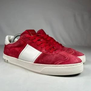 Valentino flycrew - Snygga röda sneakers från Valentino Garavani med vit sidopanel och platt sula. Ovandelen är i mocka och skinn, med röda snören och rund tå. Perfekt för dig som vill sticka ut med exklusiva och trendiga skor.