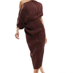 Brun plisserad offshoulder klänning - Snygg brun långklänning med plisserat tyg och offshoulder-design. Klänningen har en asymmetrisk överdel och smal passform som framhäver siluetten. Perfekt för dig som gillar unika detaljer och stilren look.