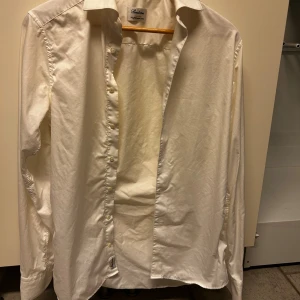 Vit skjorta från Stenströms - Klassisk vit skjorta från Stenströms i twofold super cotton. Skjortan har lång ärm, knappar framtill och en snygg krage. Perfekt för dig som gillar stilrena och tidlösa plagg. Passar dig som vill ha en clean och fräsch look.