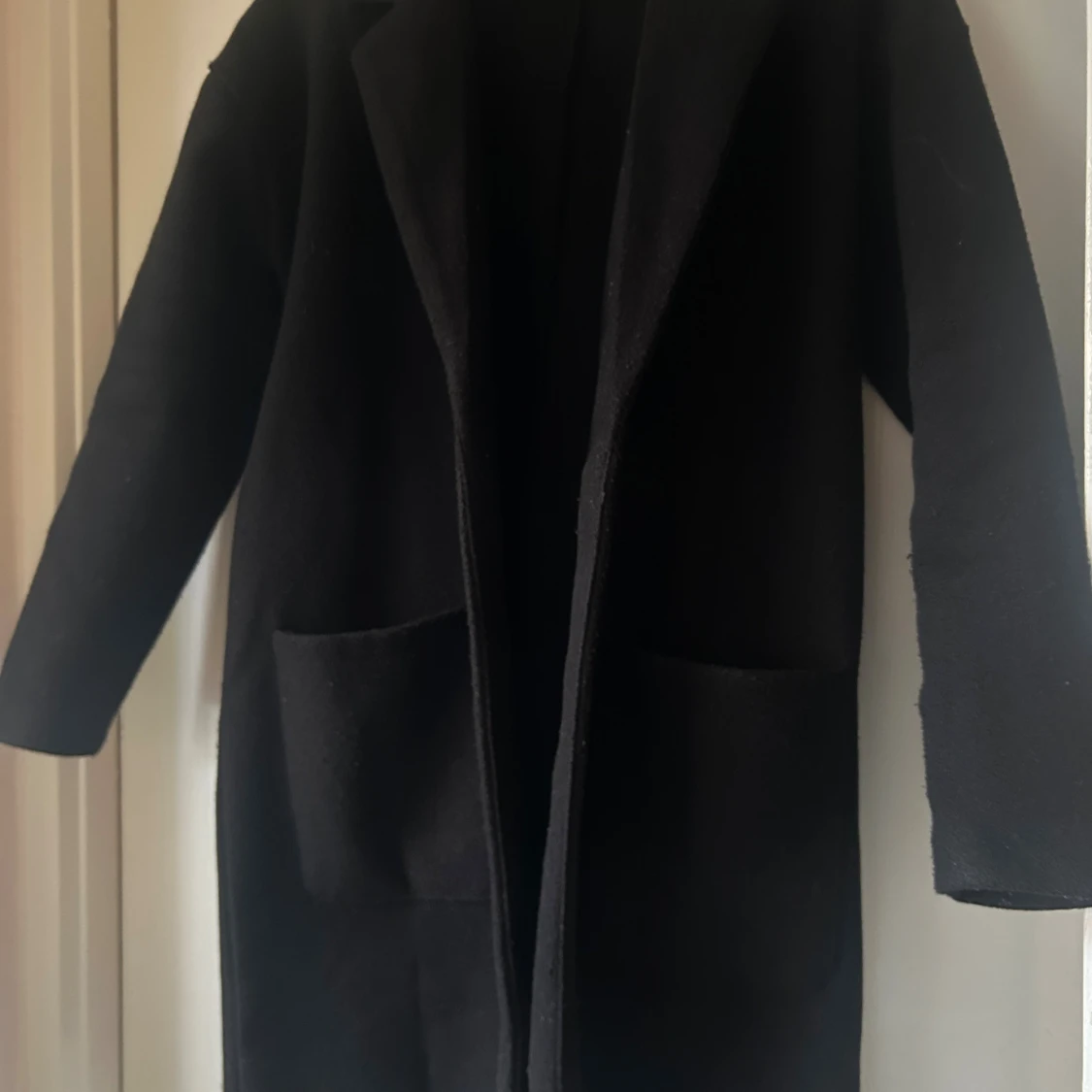 Svart kappa med bälte och fickor