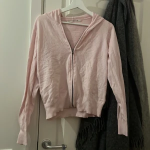 Ljusrosa hoodie med dragkedja 157 - Säljer en ljusrosa hoodie från 157 i storlek M. Tröjan har huva, långa ärmar och dragkedja framtill. Mjuk bomullskänsla och ribbade muddar vid ärmslut och nederkant. Perfekt för chill dagar och enkel att matcha med jeans eller leggings.