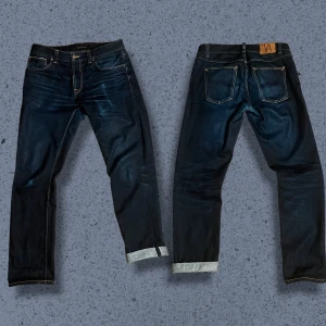 Nudie Jeans Dry Maze Selvage - W32 L32 Jeansen är i väldigt bra skick, det börjar synas fades, tex vid vänstra fickan! Jeansen har tvättats en gång. Markeringarna innanför byxorna beror på att jeansens köptes som 38-års present.  Mått (+-1): Midja 44cm Längd 105 cm Lår 30cm Benöppning 19cm Innersöm 78cm  Tveka inte att höra av dig vid minsta fundering! Priset är ej hugget i sten.