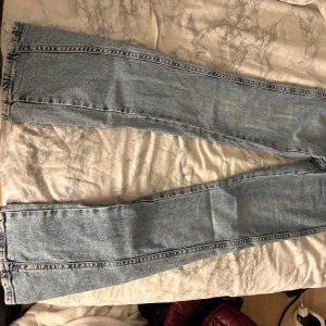 Perfekt Jeans ljusblå raka jeans - Säljer ett par ljusblå jeans från Perfekt Jeans i storlek 32. Modellen har raka ben och klassisk femficksdesign med snygga detaljer på bakfickorna. Jeansen är tillverkade i jeansmaterial och har en normal passform. Perfekt för dig som gillar stilrena och tidlösa jeans.