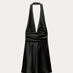 Svart halterneck klänning i satin - Supersnygg svart kort klänning med halterneck med djup v-ringning, öppen rygg med rosett . Aldrig använd och är perfekt nu till nyår. Skriv för fler bilder.