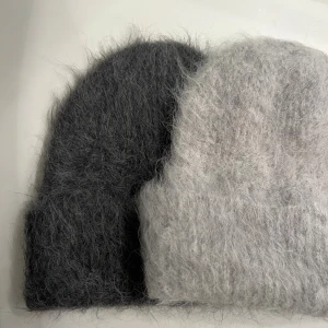 Fluffiga mössor i grått och ljusgrått - Två supermjuka och fluffiga mössor i grå och ljusgrå färg. Båda har enkel, klassisk form med uppvikt kant och är tillverkade i ett ulligt material som ger en mysig vibe. Perfekt för kalla dagar när du vill hålla dig varm och samtidigt se chill ut.399kr/st 
