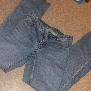 Blå raka jeans från Monki - Klassiska blå jeans från Monki med raka ben och normal passform. Jeansen har fem fickor, bälteshällor och stängs med dragkedja och knapp. Perfekta för en avslappnad och stilren look.