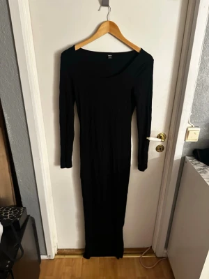 Svart långärmad maxiklänning SHEIN - Svart långklänning från SHEIN i storlek S. Klänningen har lång ärm, rundad halsringning och en tight passform som framhäver siluetten. Perfekt för dig som gillar minimalistisk och stilren look.