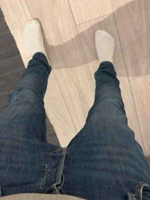 Mörkblå skinny jeans - Säljer ett par mörkblå skinny jeans med klassisk femficksdesign och smal passform hela vägen ner. Jeansen har en enkel look utan slitningar och är tillverkade i ett mjukt jeansmaterial som sitter tajt men ändå bekvämt.