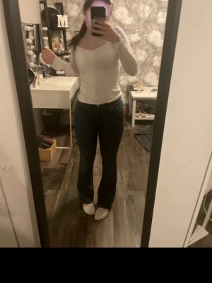 Mörkblå bootcut jeans - Säljer ett par mörkblå jeans bootcut och klassisk . Jeansen har en normal passform och är tillverkade i ett stretchigt denimtyg som sitter snyggt över höfterna och låren. Perfekta för dig som gillar en tidlös look med lite utsvängda ben.